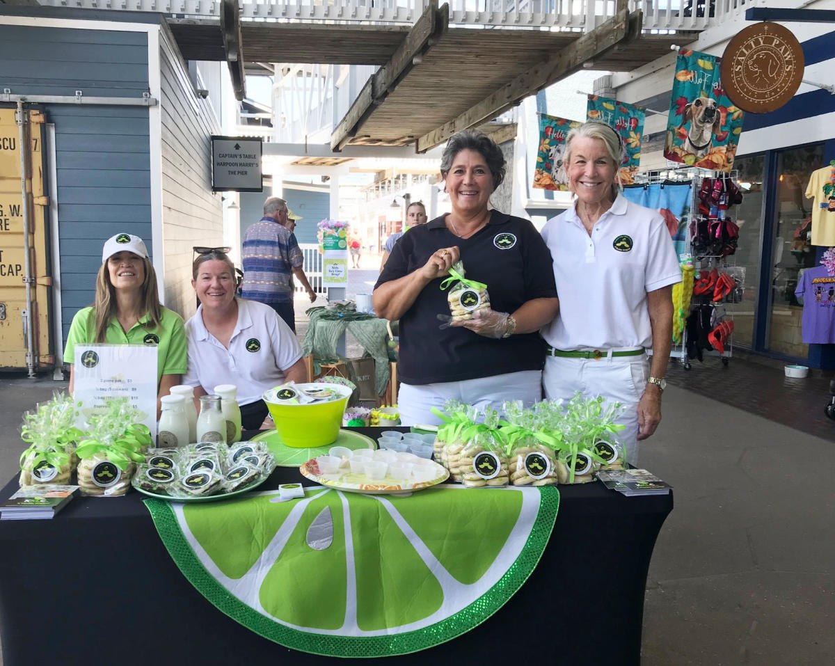 Vendors at a Key Lime Fest booth offering key lime samples at Fisherman's Village